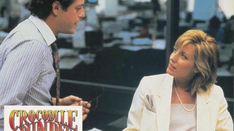 Crocodile Dundee German lobby card 10 Lobby card depicting Sue Charlton (Linda Kozlowski) speaking with her newspaper editor beau Richard Mason (Mark Blum)