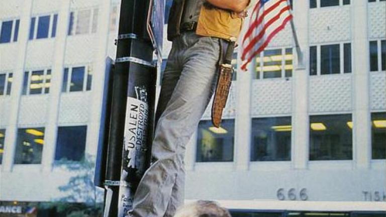Crocodile Dundee German lobby card 13 Lobby card depicting Mick Dundee standing up high, hanging on a light pole in New York City
