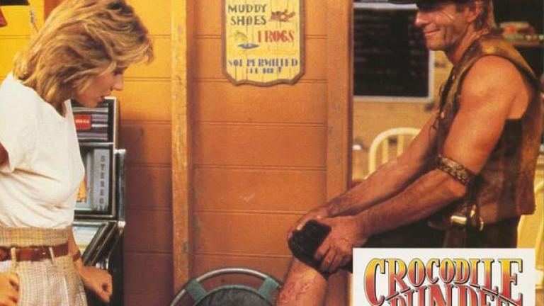 Crocodile bite scar Lobby card depicting Mick Dundee showing off his crocodile bite scar to Sue Charlton.
