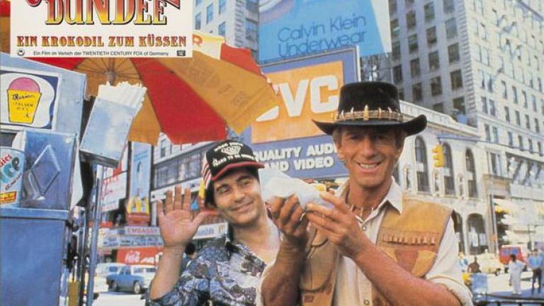 Crocodile Dundee German lobby card 9 Lobby card depicting Paul Hogan as Mick Dundee holding a hot dog and smiling for the camera in New York City