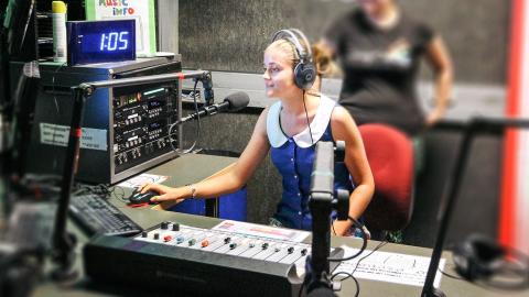 Two young women at a radio mixing desk at SYN Media