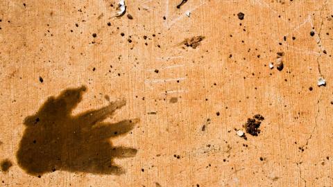 A hand print on rocky desert sand