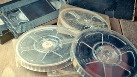 A stack of film reels and video tables scattered on a table