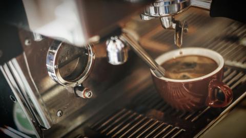 Close up of a coffee machine and a cup being filled with coffee.