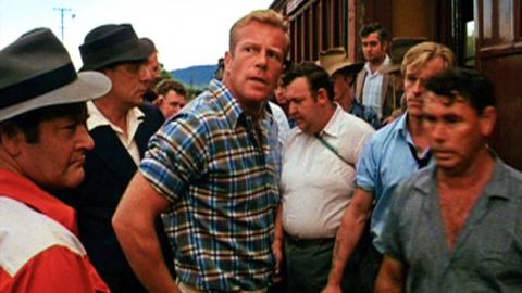 Jack Thompson stands in the middle of a group of sheep shearers by a train in Sunday Too Far Away