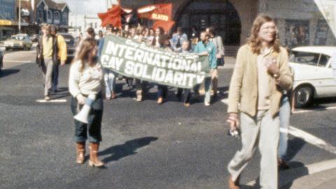 People at a protest march holding banners and loudspeakers