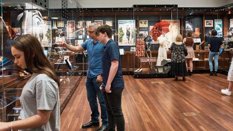 People looking at items in an exhibition space.
