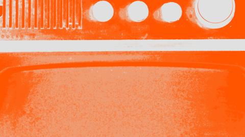 A close-up image of a radio speaker and dials that has been tinted orange