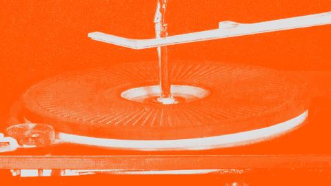 A treated image of a record player and stylus that has been tinted orange