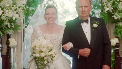 A scene from Muriel's Wedding - Muriel is in her wedding dress and is being walked down the aisle of a church by her father. 