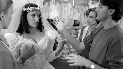 Toni Collette in a wedding dress standing with director PJ Hogan in a bridal store shooting a scene from Muriel's Wedding.