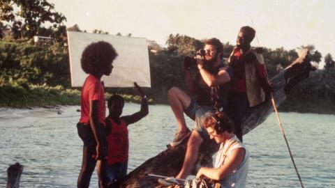 Filmmakers Chris Owen and Albert Toro balanced on a log overhanging the water and filming an actor in a scene from the film Tukana, shot off the coast of Papua New Guinea.