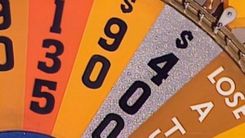 A close-up of the game wheel from TV show Wheel of Fortune showing segments with cash prizes and Lose a Turn.