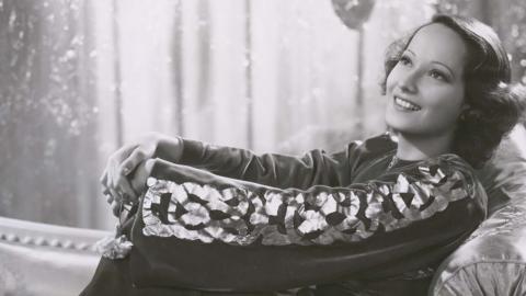 Merle Oberon reclining on a chaise longue
