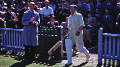 Cricketer Sir Donald Bradman walks onto the Sydney Cricket Ground ready to bat.