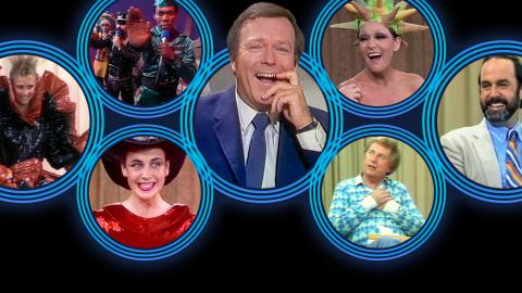 Seven blue rings sit on a black background. There are people in each ring. Clockwise from left a model wearing an 80s dress, The Village People strike a pose, Mike Walsh, Jeanne Little, John Cleese, John Michael Howson and a woman with a hair hat.