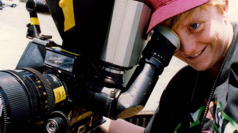 Cinematographer Jane Castle looking through the viewfinder of a film camera
