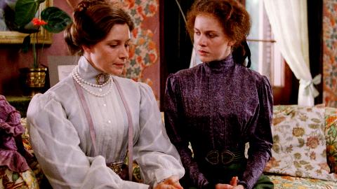 Wendy Hughes and Judy Davis seated on a couch talking in a still from My Brilliant Career