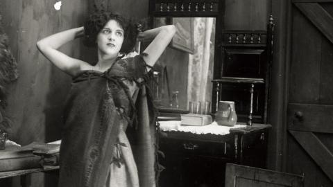 Still image from Moth of Moonbi showing Doris Ashwin standing with hands behind her head