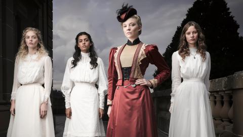 Four womern standing in a line in period costume