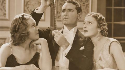 Publicity still of Shirley Ann Richards as Lorna Quidley, Lloyd Hughes as Daubenny Carshott and Elaine Hamill as Stella Raff examining a film strip.