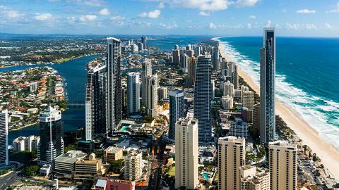 Gold Coast_1600x775 Aerial photo of the Gold Coast showing long stretch of beach, ocean and high rise buildings.