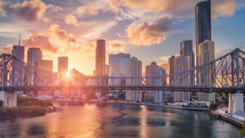 Brisbane in early morning with the sun shining on city buildings and the Brisbane River