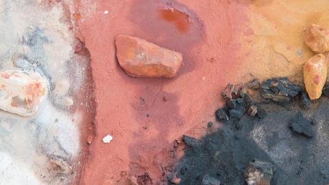 View from above of four Aboriginal art colours - white, red, yellow and black - used traditionally from natural materials in nature.