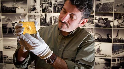 Warren Brown holds up a gold cigarette case at the National Archives of Australia