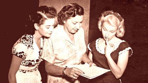 Grace Gibson (centre) looks over a radio serial script with two actresses. 