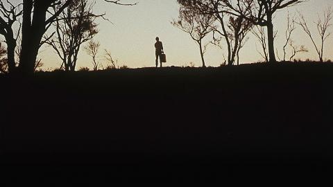 Australian horror A still image from Wake in Fright shows a silhouetted man surrounded by trees