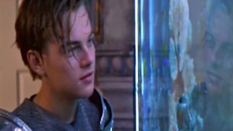 Leonardo DiCaprio as Romeo looks at Juliet through the glass of an aquarium.