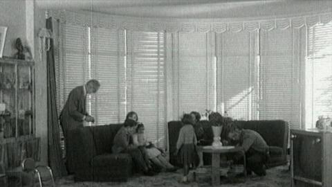 Wide shot of two little Aboriginal girls in the living room of their adopted white family