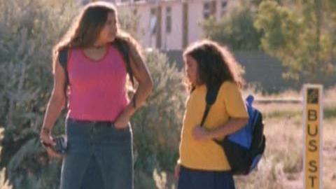 Two sisters walk to the bus stop on the way to school