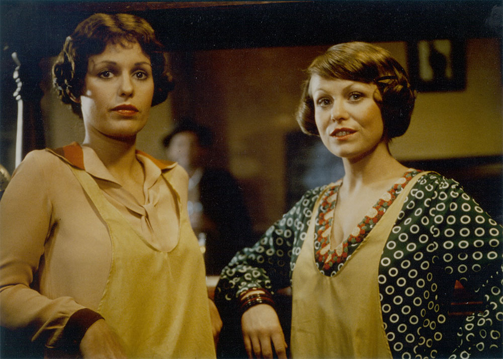 Film still of Helen Morse and Jacki Weaver in period costume in Caddie